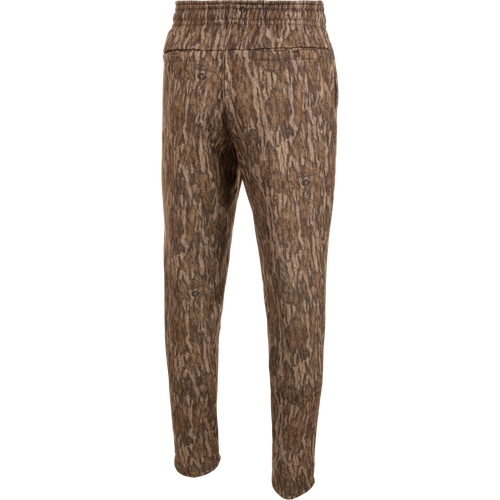 Drake Under-Wader Jogger, camouflage pants with tree pattern, designed for warmth, comfort, and durability under waders, featuring tapered legs, elastic waist, and multiple pockets.