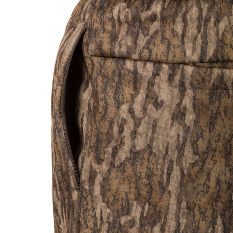 Close-up of Drake Under-Wader Jogger's front slash pocket on camouflage fabric, showcasing durable construction and storage features.