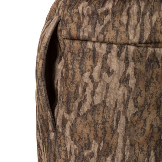 Close-up of Drake Under-Wader Jogger's front slash pocket on camouflage fabric, showcasing durable construction and storage features.