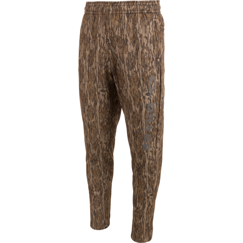 Drake Under-Wader Jogger with camouflage pattern, featuring front slash pockets, hook and loop closure rear pockets, and tapered legs for secure fit under waders.