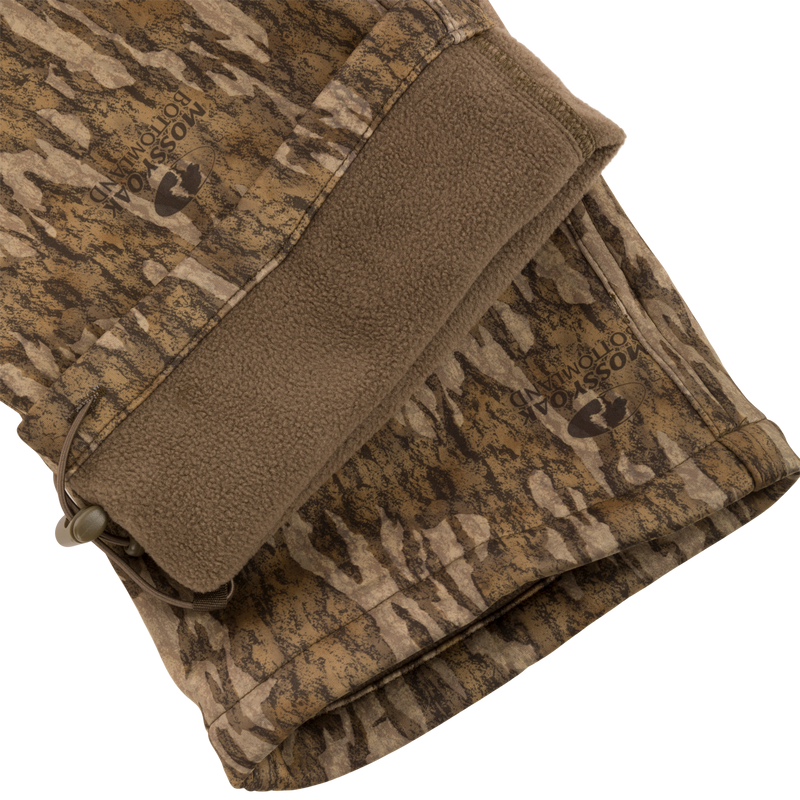 Close-up of the Endurance Jean Cut Wader Pant, highlighting its camouflage pattern and durable design with front slash pockets and an adjustable waist.