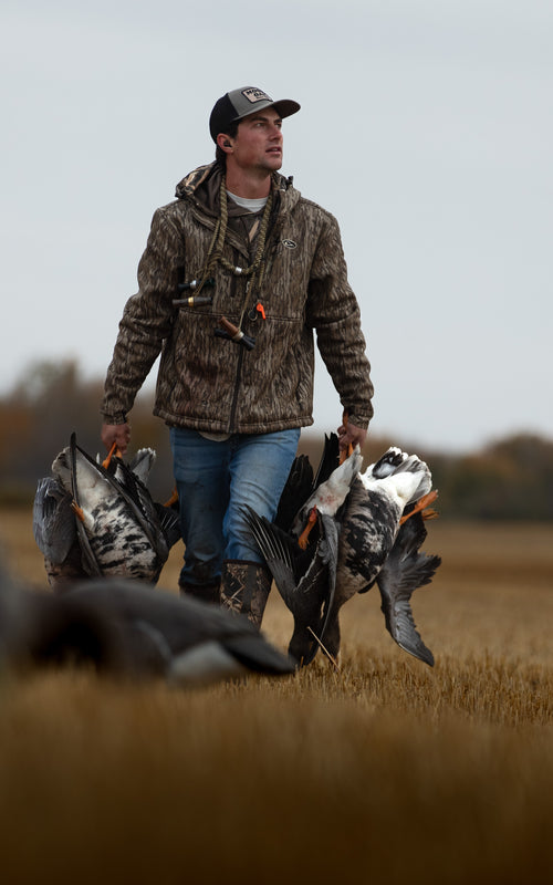 Ultimate Wader Quarter Zip Hoodie worn by a hunter outdoors, showcasing its hand-warmer pockets, Sherpa lining, and adjustable waist, perfect for layering in mid-season.