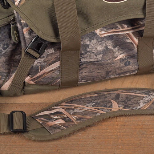 Floating Blind Bag 2.0 - Large: A camouflage bag with straps, a black plastic buckle, and a roll of fabric on a black surface.