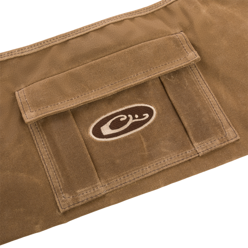 Close-up of the Wax Cotton Gun Sleeve, showcasing its wax canvas material and brown and white logo, designed for protecting and transporting shotguns.