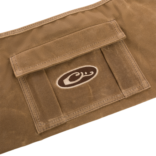 Close-up of the Wax Cotton Gun Sleeve, showcasing its wax canvas material and brown and white logo, designed for protecting and transporting shotguns.