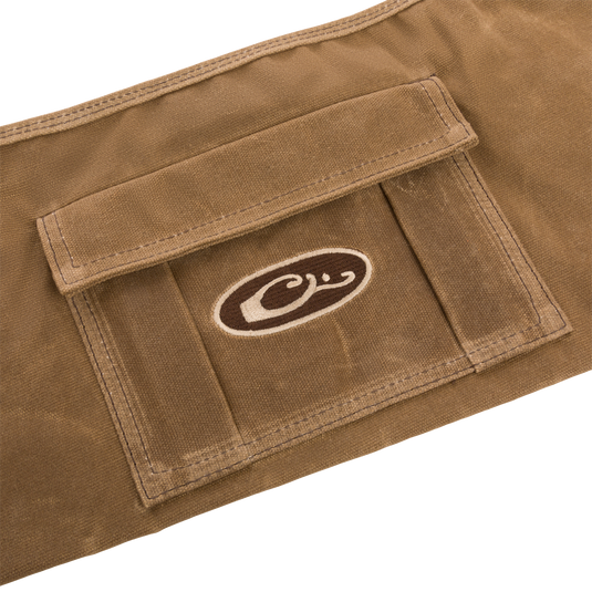 Close-up of the Wax Cotton Gun Sleeve, showcasing its wax canvas material and brown and white logo, designed for protecting and transporting shotguns.