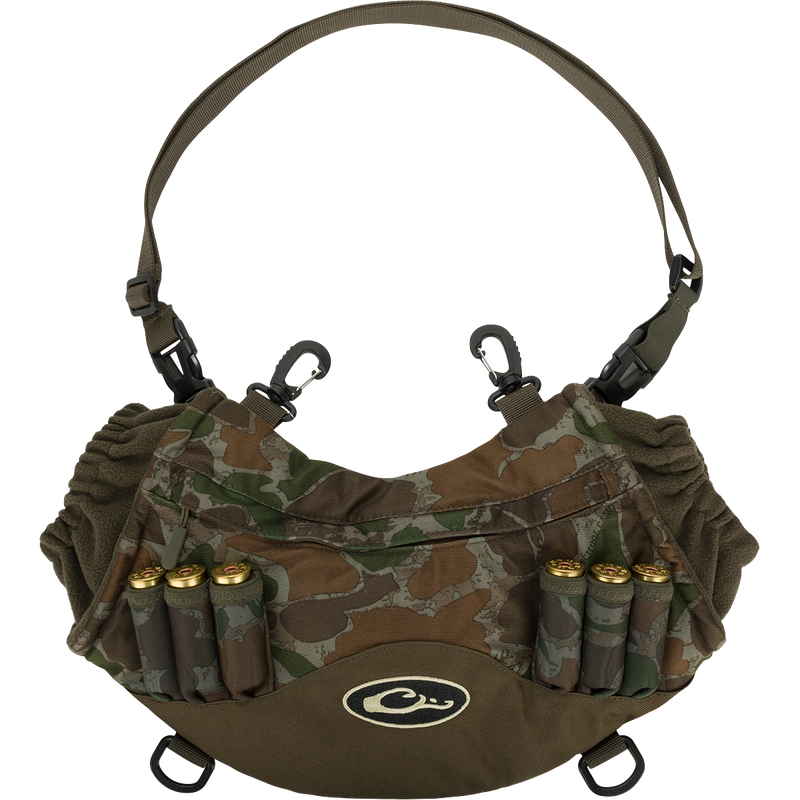 Camouflage Drake LST Handwarmer Muff with ammo loops, front storage pocket, clear waterproof phone pouch, waist belt, and carabiner clips for attaching to waders.