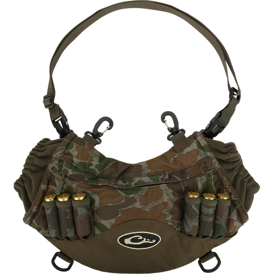 Camouflage Drake LST Handwarmer Muff with ammo loops, front storage pocket, clear waterproof phone pouch, waist belt, and carabiner clips for attaching to waders.