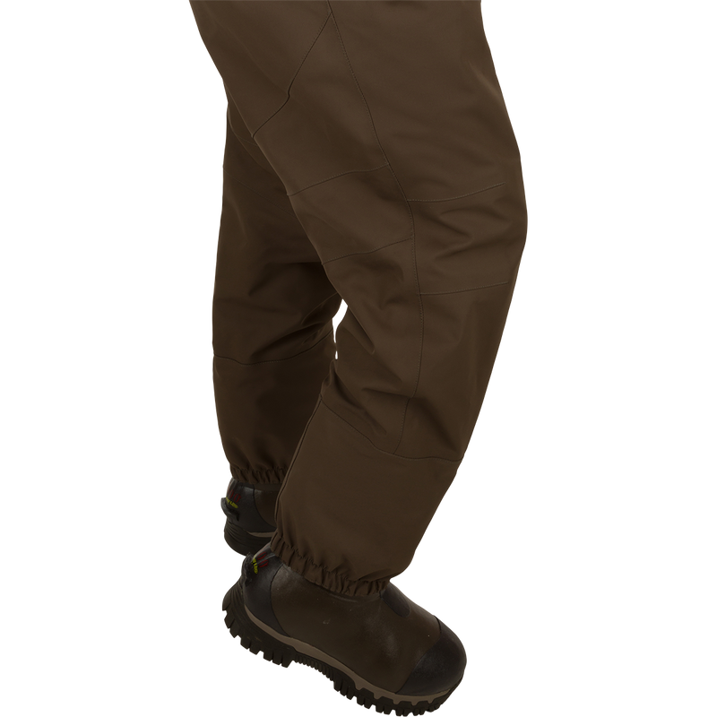 Uninsulated Guardian Elite HND Front Zip Wader - Original Treestand: A person wearing brown pants and boots, standing in a marsh.