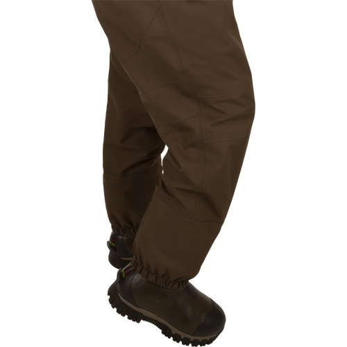 Uninsulated Guardian Elite HND Front Zip Wader - Original Treestand: A person wearing brown pants and boots, standing in a marsh.