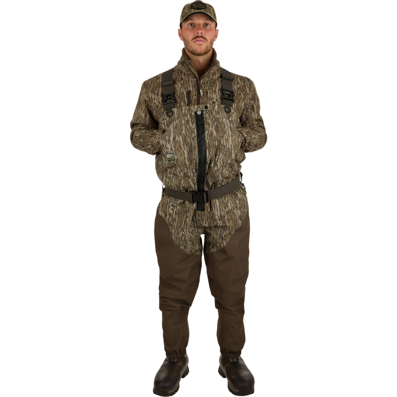 A man wearing the Guardian Elite Hybrid Insulated Front Zip Wader in a camouflage pattern, showcasing the durable, waterproof, and breathable hunting gear.