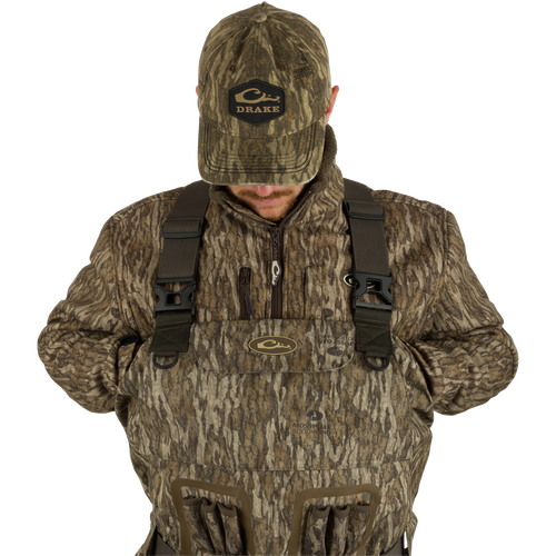 A man in Insulated Guardian Elite Vanguard Breathable Waders, featuring 100% waterproof fabric, LokDown insulation, and Thinsulate Buckshot Mudder boots. From Drake Waterfowl for premium hunting gear.