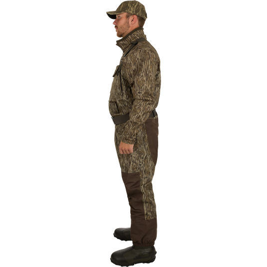 A man in military camouflage waders with close-ups of boots and hands. Insulated Guardian Elite Vanguard Breathable Waders for hunting, featuring 3-layer waterproof fabric, LokDown insulation, and Thinsulate boots.