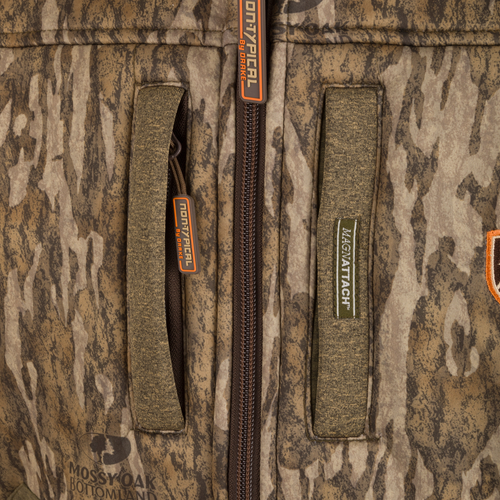 Close-up of the Youth Silencer Full Zip Jacket's zipper and label, showcasing durable fabric and hunting gear lanyards.