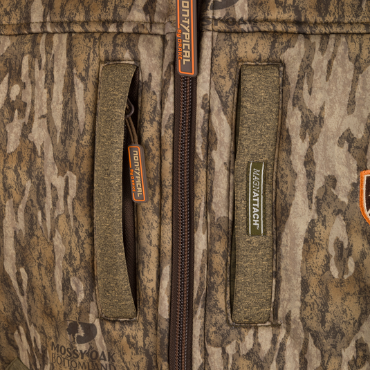 Close-up of the Youth Silencer Full Zip Jacket's zipper and label, showcasing durable fabric and hunting gear lanyards.