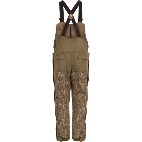 Silencer Bib: camouflage overalls with zippered and Magnattach™ chest pockets, side zippers, and scent control technology, designed for hunting.