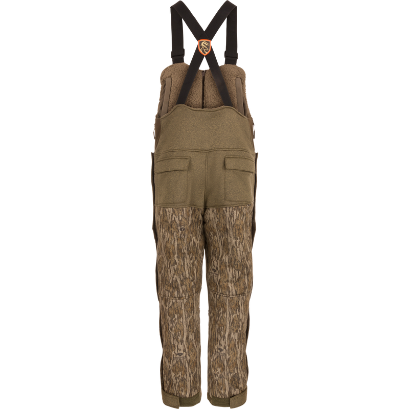 Youth Silencer Bib With Agion Active XL: Camouflage overalls designed for hunting, featuring vertical pockets, scent control technology, and full-length side zippers for easy access.