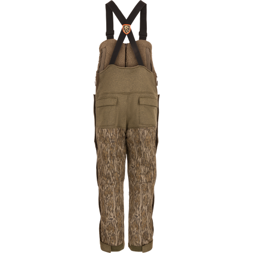 Youth Silencer Bib With Agion Active XL: Camouflage overalls designed for hunting, featuring vertical pockets, scent control technology, and full-length side zippers for easy access.