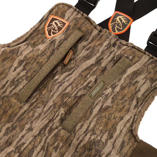 Close-up of the Youth Silencer Bib With Agion Active XL, featuring a durable outer fabric, vertical zippered pockets, and a detailed patch with a deer head.