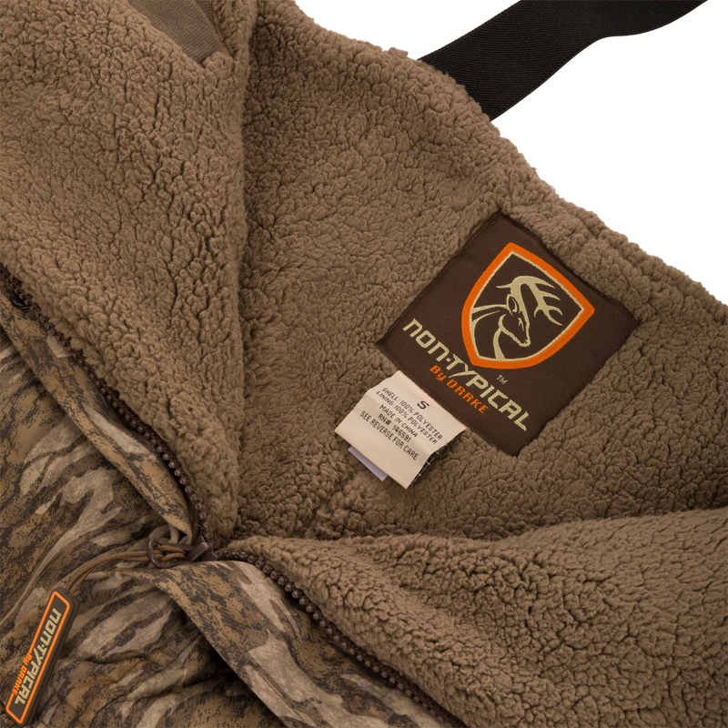Close-up of the Silencer Bib jacket showcasing its soft outer fabric, Sherpa fleece interior, and label detailing scent control technology.