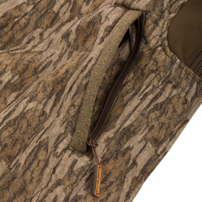 Close-up of the Silencer Bib's zipper, highlighting the durable exterior fabric and Sherpa fleece interior designed for warmth and scent control in hunting.