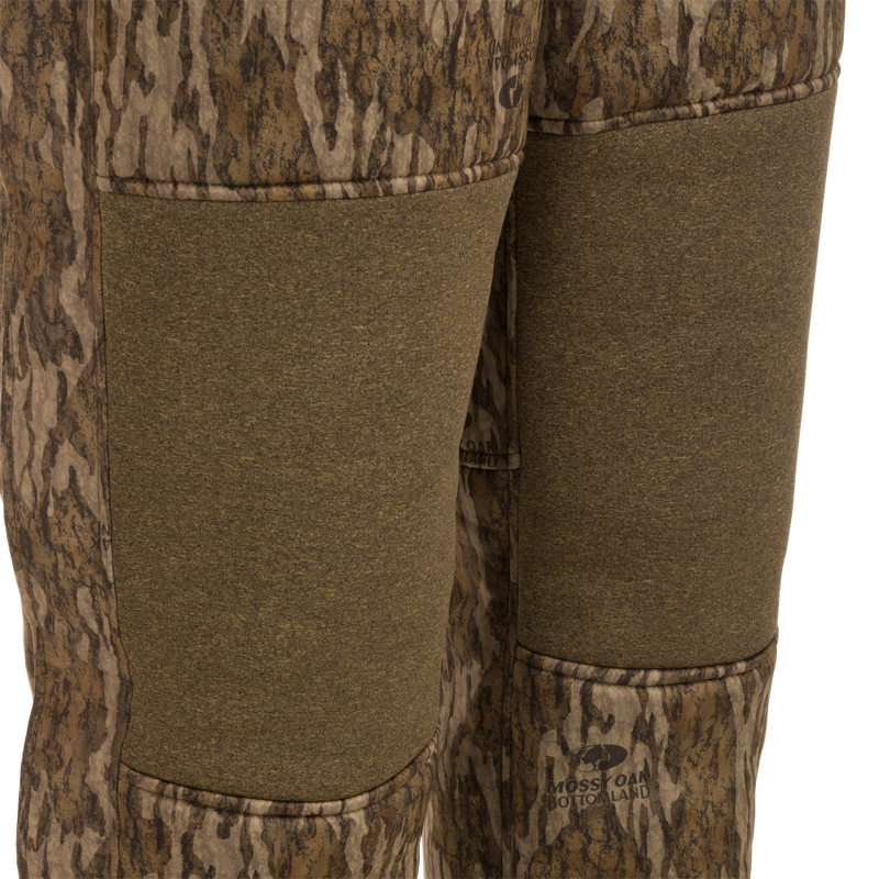 Close-up of Silencer Bib pants showcasing soft, durable fabric and vertical chest pockets with lanyards for hunting gear.