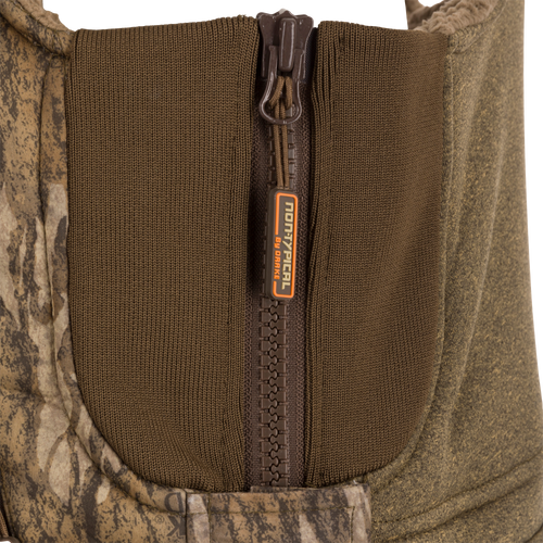 Close-up of the Silencer Bib's zipper and label, highlighting its durable outer fabric and Sherpa fleece interior designed for warmth and breathability.