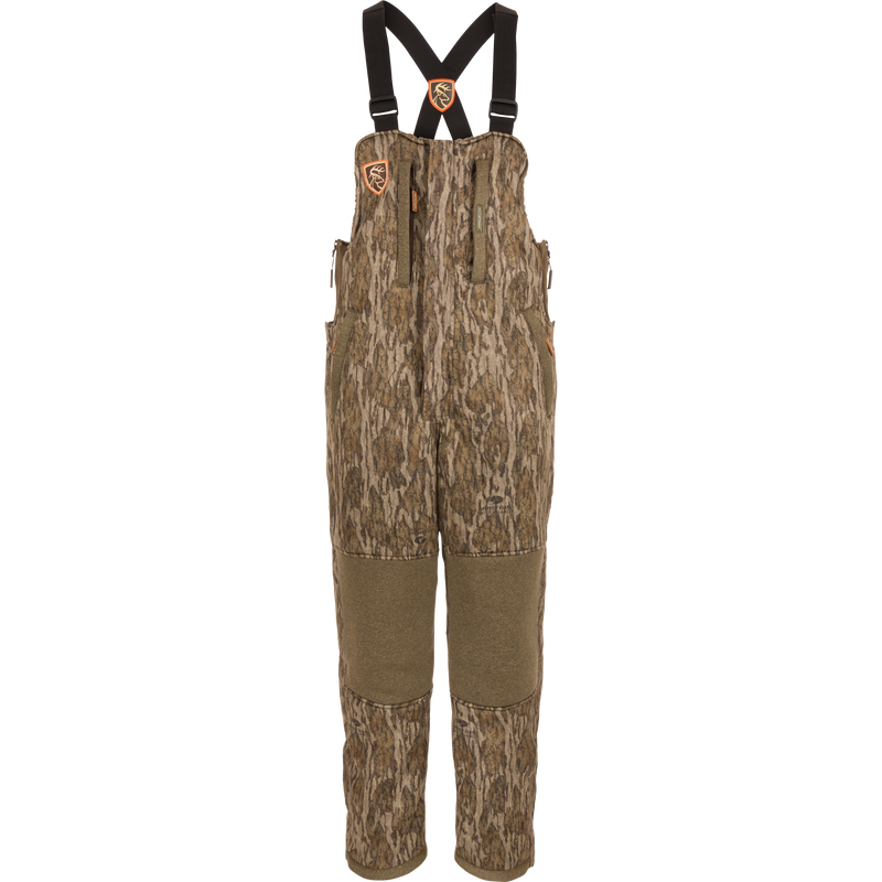 Youth Silencer Bib with Agion Active XL featuring camouflage design, adjustable straps, vertical pockets with lanyards, and durable fabric for warmth and scent control.