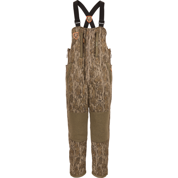 Silencer Bib: Camouflage overalls with straps, featuring vertical pockets with lanyards, full-length side zippers, and Agion Active X2® scent control technology.