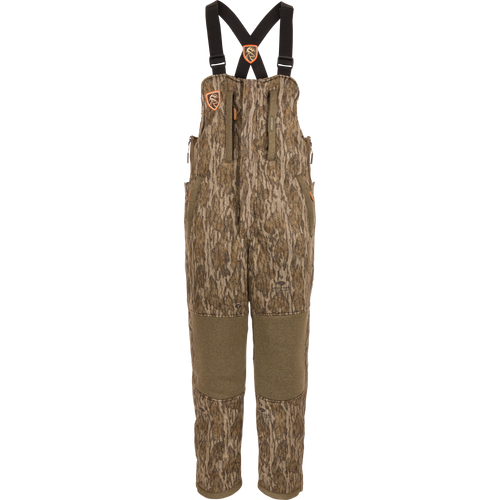 Silencer Bib: Camouflage overalls with straps, featuring vertical pockets with lanyards, full-length side zippers, and Agion Active X2® scent control technology.