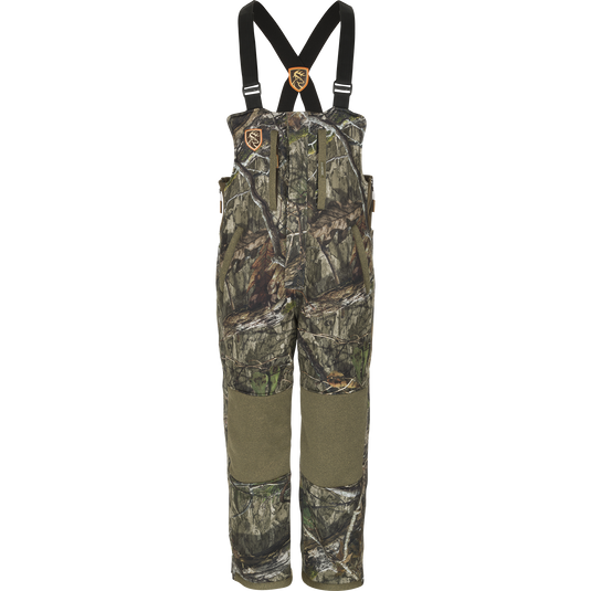 Camouflage Silencer Bib with Agion Active XL, featuring vertical pockets and lanyards, designed for durability, warmth, and scent control in hunting environments.