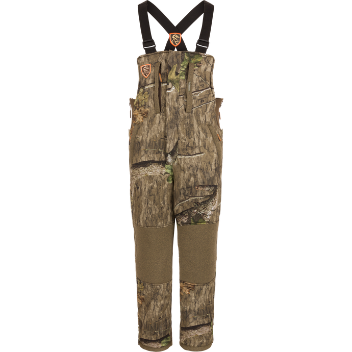 Youth Silencer Bib with Scent Control featuring camouflage design, straps, and pockets for hunting gear, made with durable, quiet fabric and Sherpa fleece interior for warmth.