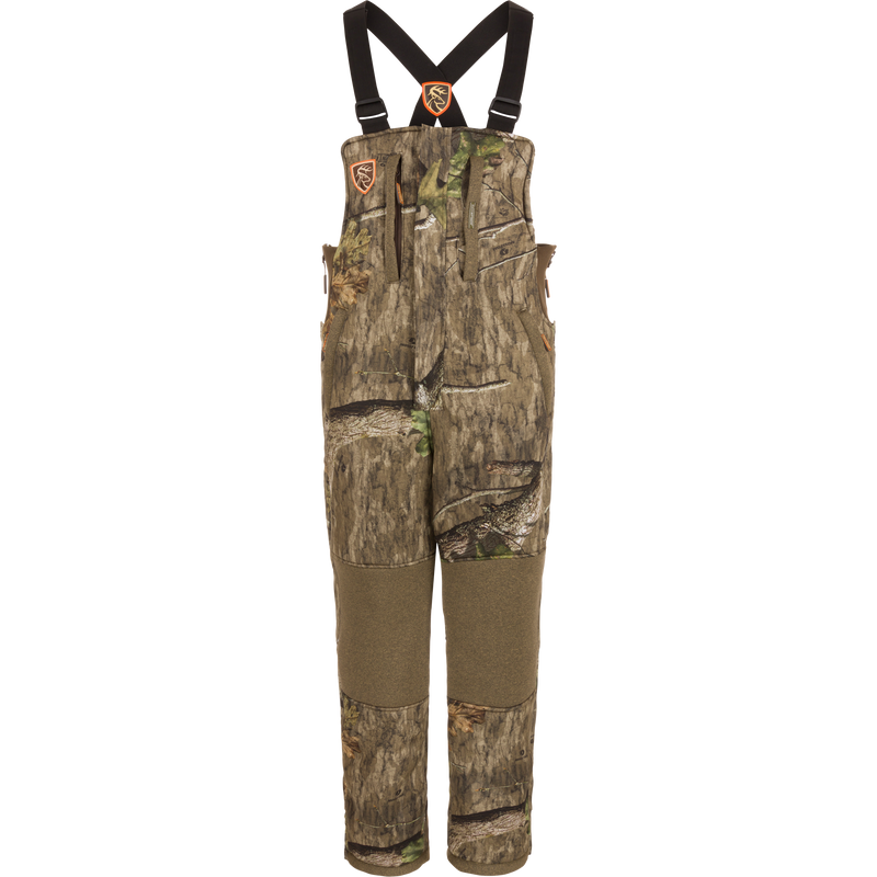 Youth Silencer Bib with Scent Control featuring camouflage design, straps, and pockets for hunting gear, made with durable, quiet fabric and Sherpa fleece interior for warmth.