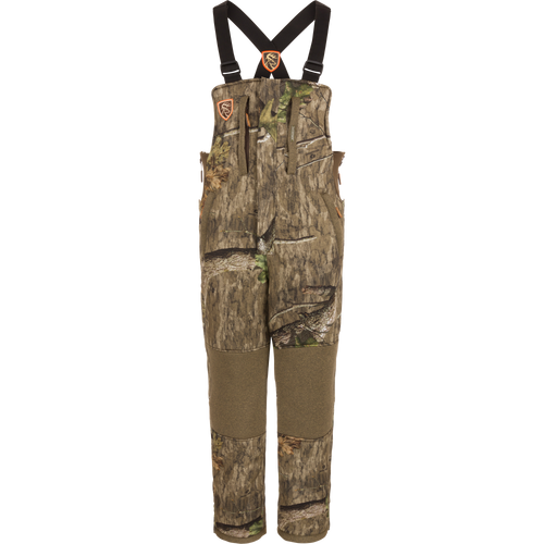 Youth Silencer Bib with Scent Control featuring camouflage design, straps, and pockets for hunting gear, made with durable, quiet fabric and Sherpa fleece interior for warmth.