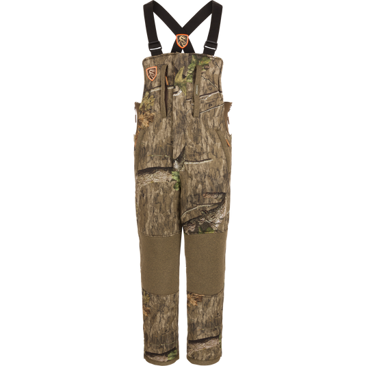 Youth Silencer Bib with Scent Control featuring camouflage design, straps, and pockets for hunting gear, made with durable, quiet fabric and Sherpa fleece interior for warmth.