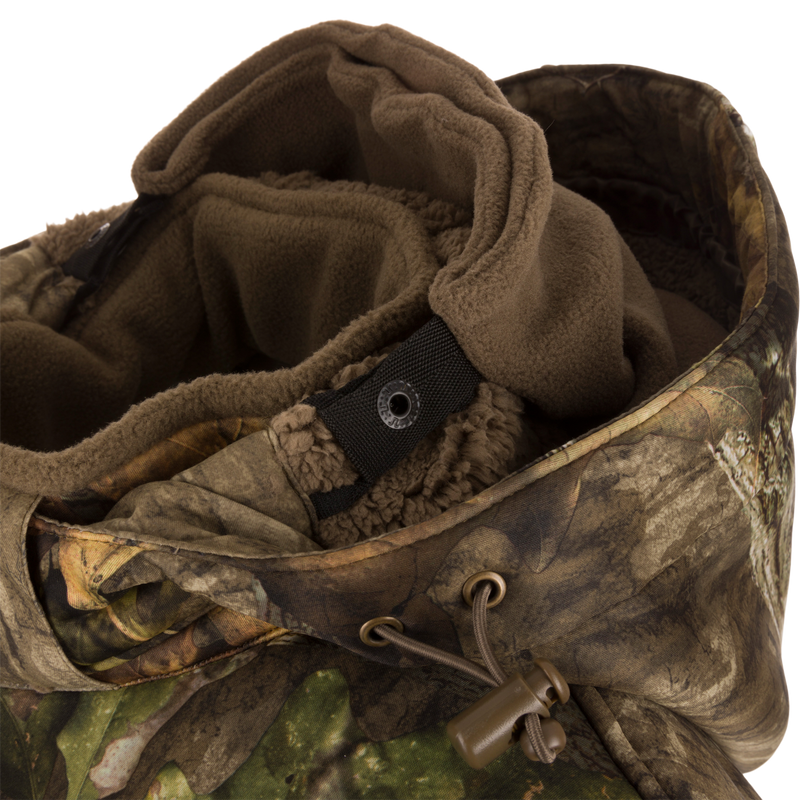 Close-up of the Stand Hunter's Silencer Jacket with Scent Control, highlighting the durable outer fabric, metal rings, and various pockets for hunting gear.