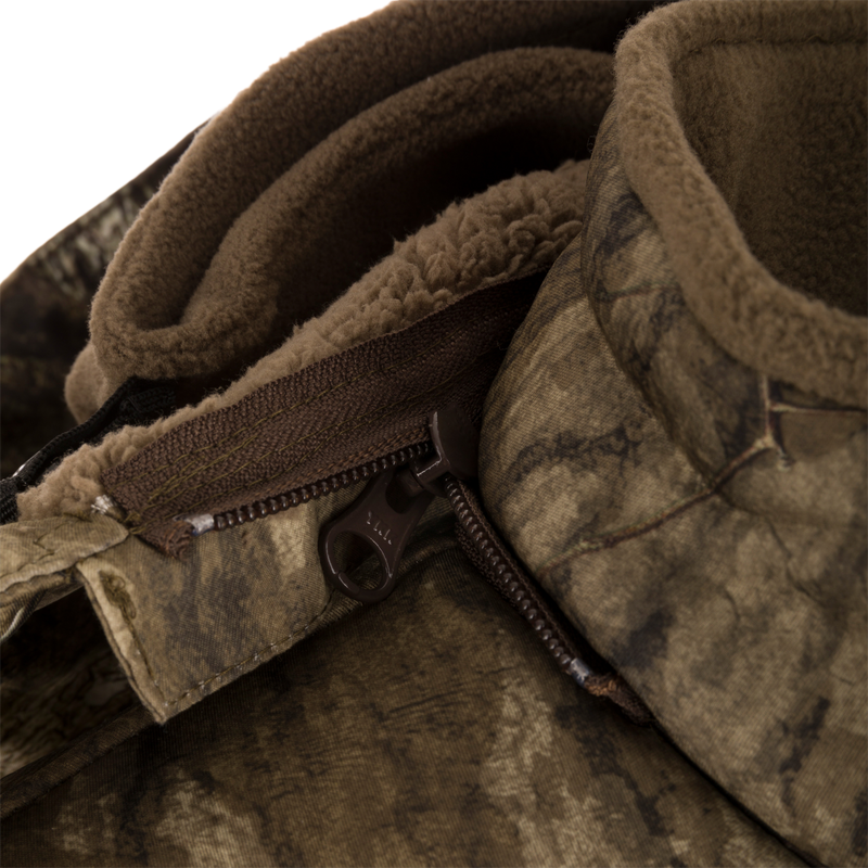 Close-up of the Stand Hunter's Silencer Jacket zipper, highlighting its durable, quiet fabric and advanced scent control technology for effective late-season hunting.