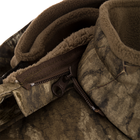 Close-up of the Stand Hunter's Silencer Jacket zipper, highlighting its durable, quiet fabric and advanced scent control technology for effective late-season hunting.