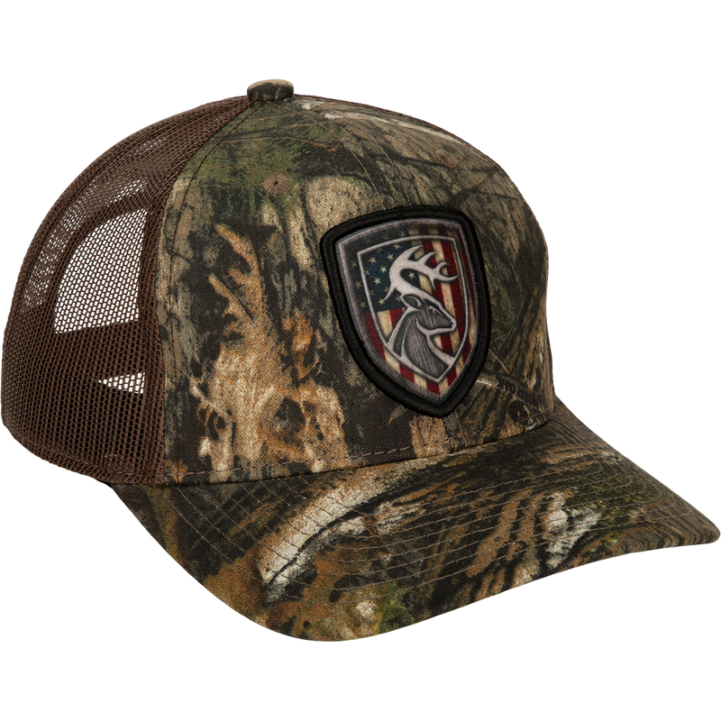 Americana Shield Patch Mesh-Back Cap with deer head and flag patch, breathable mesh back, lightly structured cotton twill front, and adjustable snap closure.