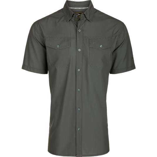 Alt text: Close-up of the Traveler's Check Button-Down Short Sleeve Shirt, featuring button flaps on chest pockets and lightweight, breathable poly/spandex fabric.
