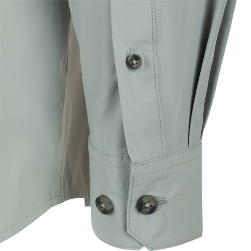 Close-up of a button on the Drake Wingshooter Trey Shirt L/S, showcasing its detailed craftsmanship and performance fabric.