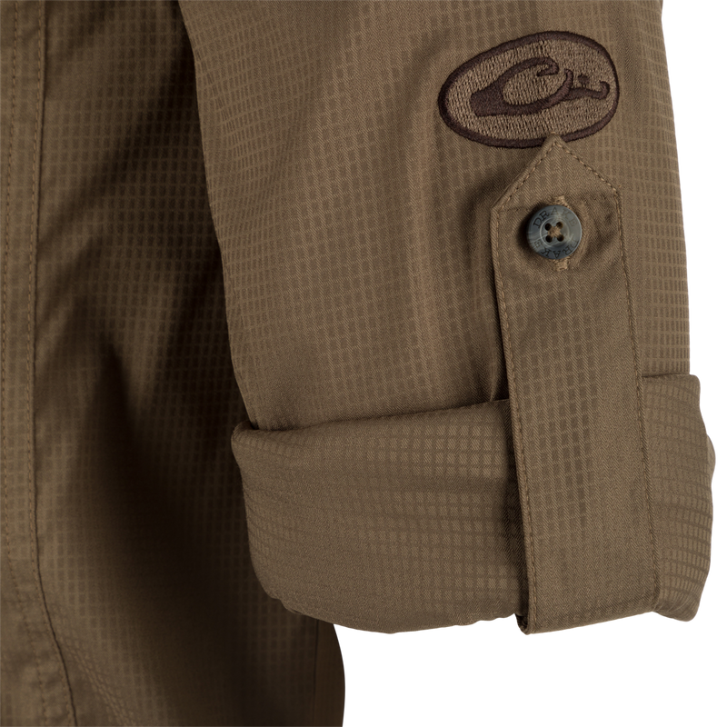 Close-up of the Wingshooter's Trey Dobby Button-Down Long Sleeve Shirt, showcasing a button detail on textured fabric with adjustable cuff.