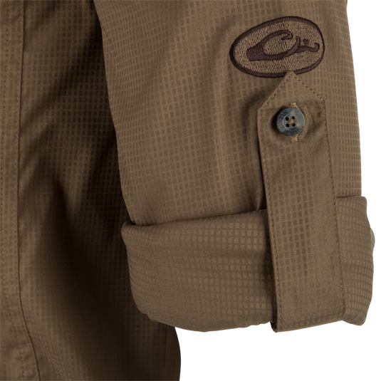 Close-up of the Wingshooter's Trey Dobby Button-Down Long Sleeve Shirt, showcasing a button detail on textured fabric with adjustable cuff.