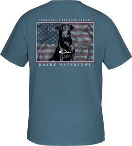 A blue shirt with a dog and an American flag overprint, featuring the Drake logo pocket on the front - Americana Lab T-Shirt.