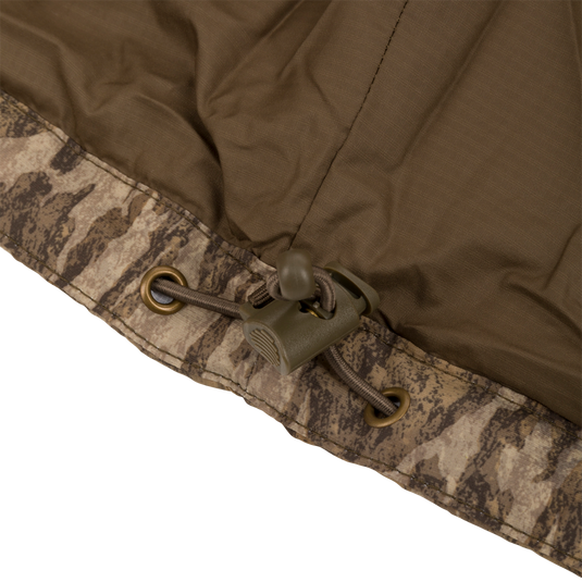 Close-up of the MST Synthetic Down Pack Jacket's zipper and drawcord, showcasing its durable fabric and functional design for versatile hunting and outdoor use.