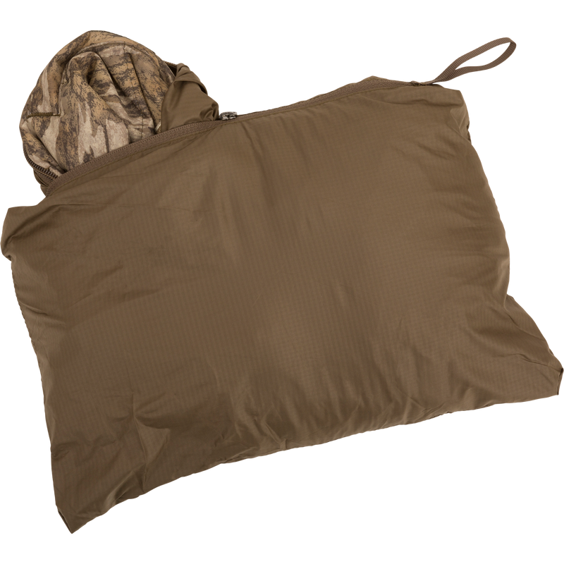 MST Synthetic Down Pack Vest shown packed in brown bag with visible camouflage cloth inside.