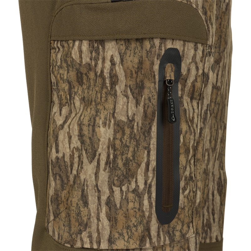 Close-up of MST Tech Stretch Bibs showing camouflage fabric, zippered leg pocket, and sturdy construction details. Ideal for versatile, comfortable hunting gear.