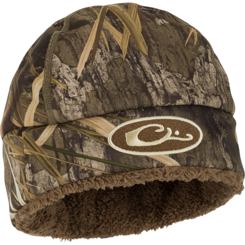 A close-up of the LST Windstopper Beanie, featuring a camouflage hat with a logo and fur lining.