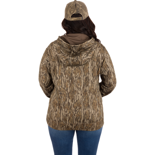 Woman wearing the Women's MST Performance Hoodie with double-lined hood, kangaroo pouch, and soft combed fleece interior, styled for everyday and field use.