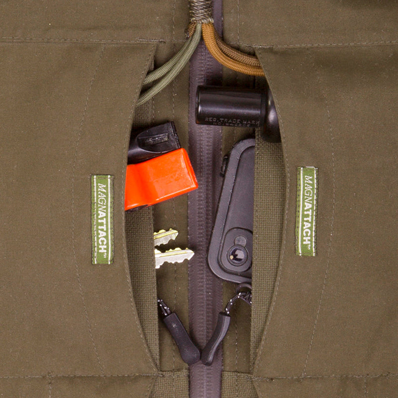 A red Guardian Elite Timber/Field Jacket with key pocket and drain holes for wading. Features adjustable hood, multiple pockets, and BMZ System.